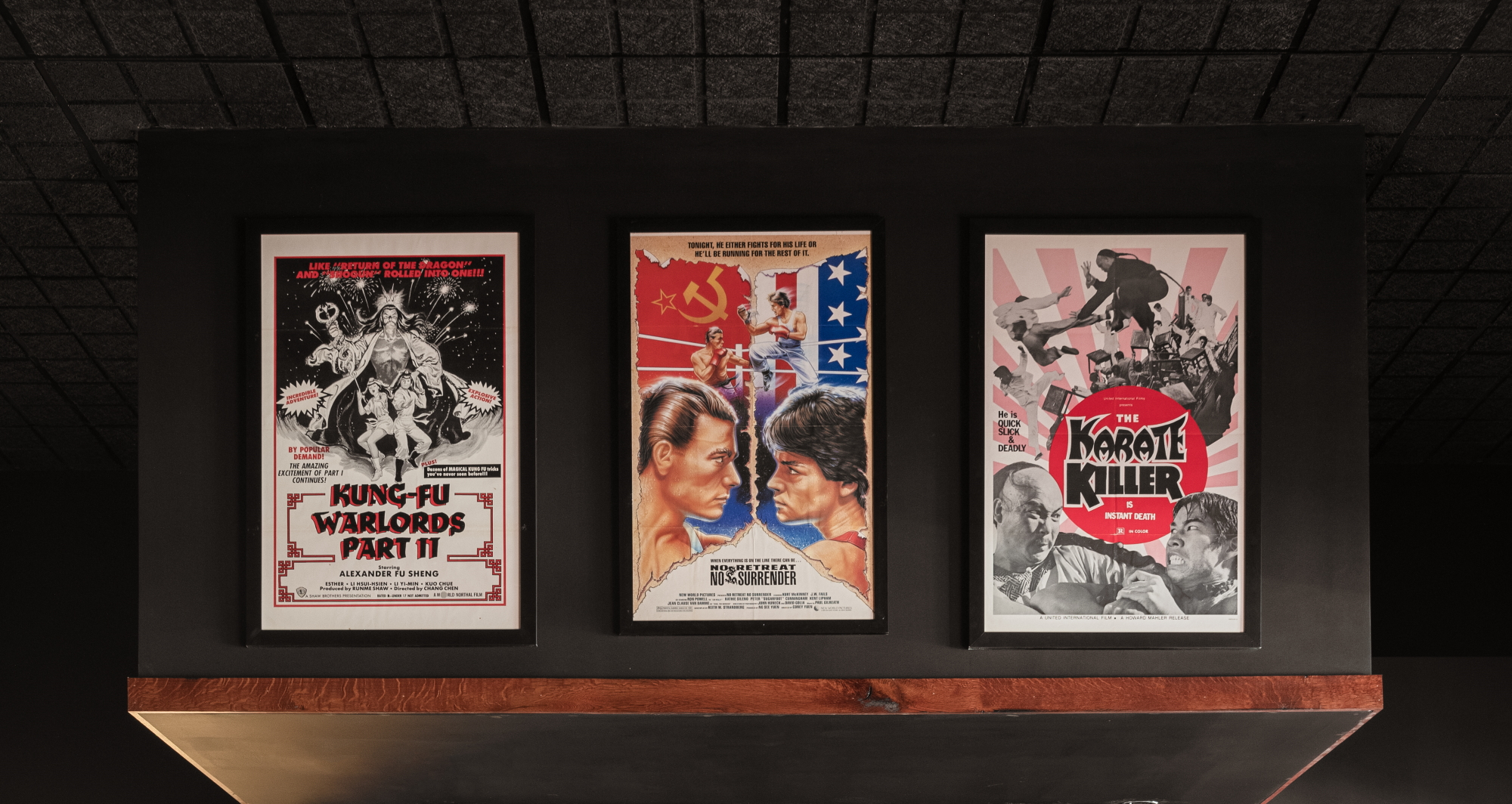 Hung up from left to right are posters for the movies "Kung-Fu Warlords Part II", "No Retreat, No Surrender", and "The Karate Killer"