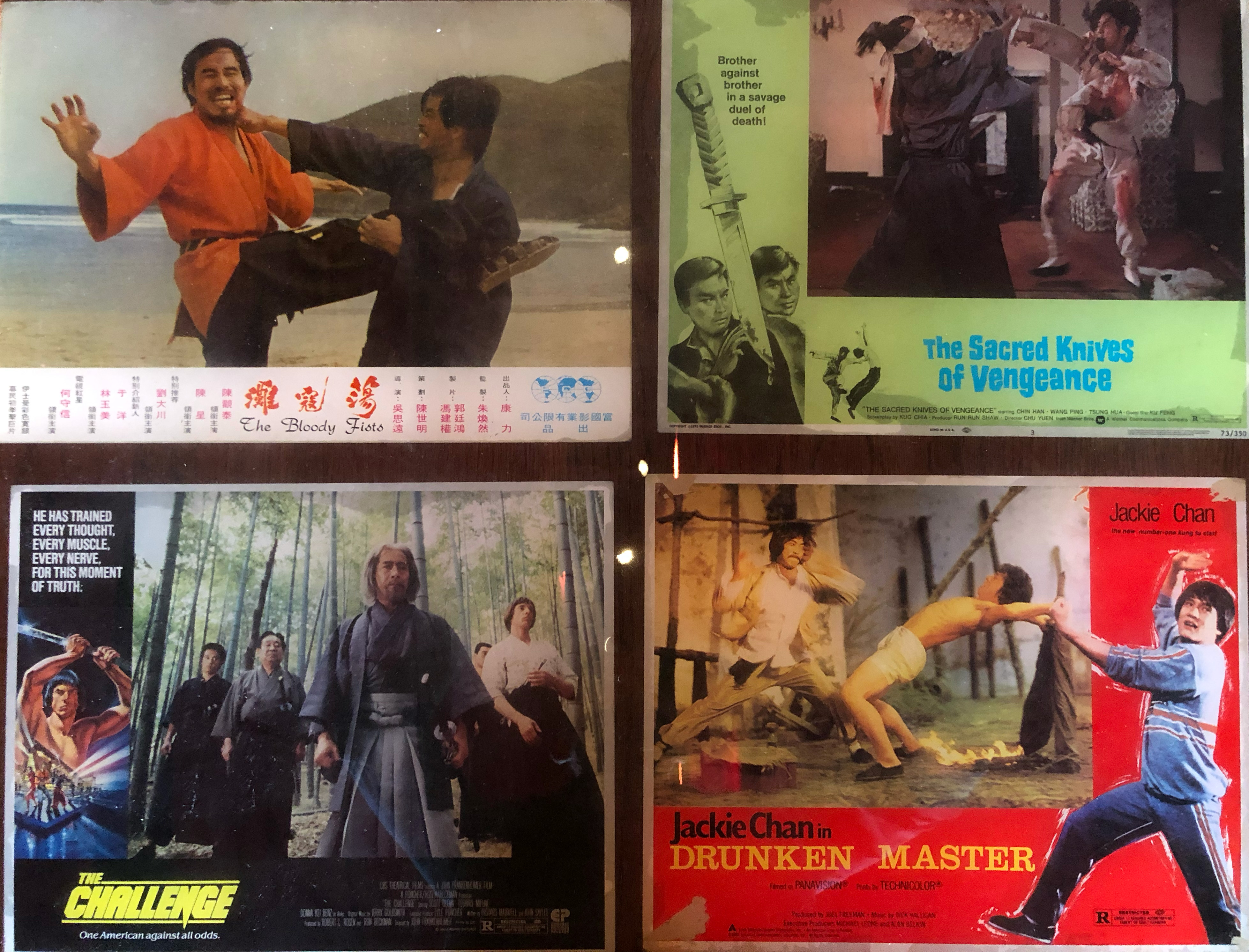 Close up of a set of four posters of for (from top right to bottom left) "The Bloody Fists", "The Sacred Knives of Vengeance", "The Challenge", and "Drunken Master" starring Jackie Chan.
